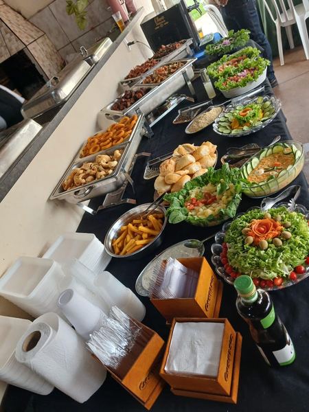 Mesa de buffet completo com carnes, saladas e acompanhamentos
